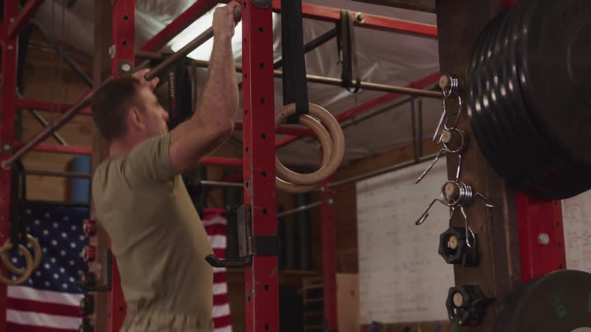 A man does pull ups as he exercises