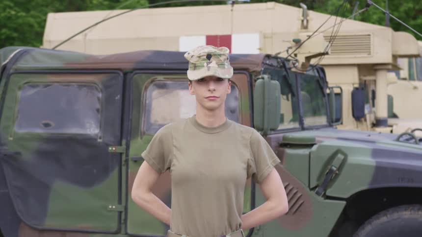 Female soldier standing in front of a military jeep