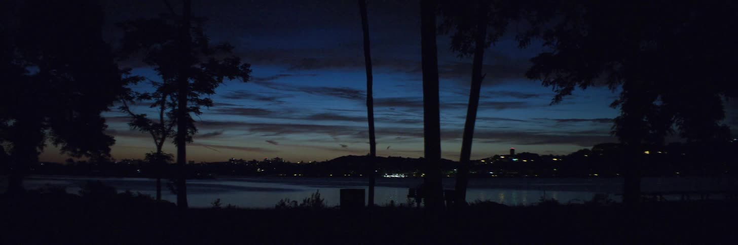 The sun is nearly set near the city shore