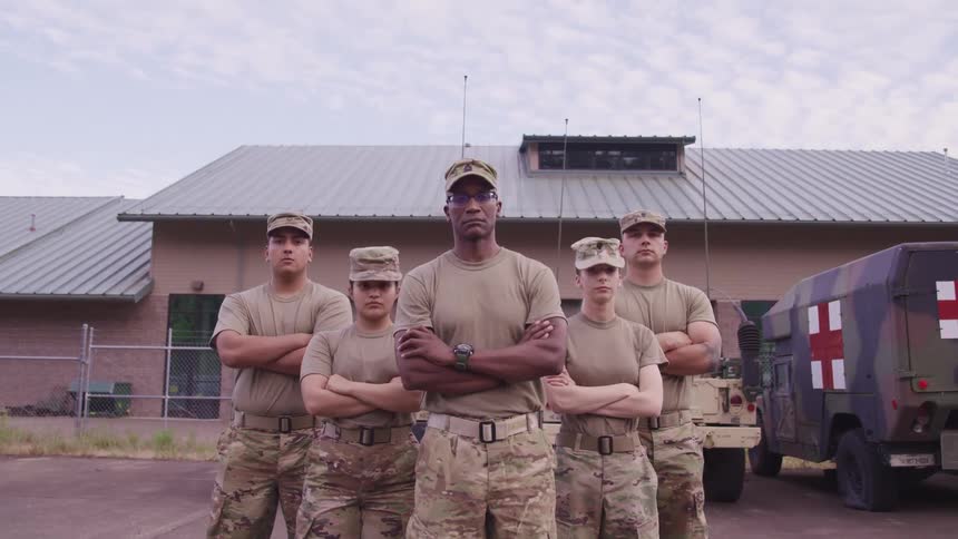 Soldiers in military uniform standing and staring with vehicles a building the sky and clouds in the background