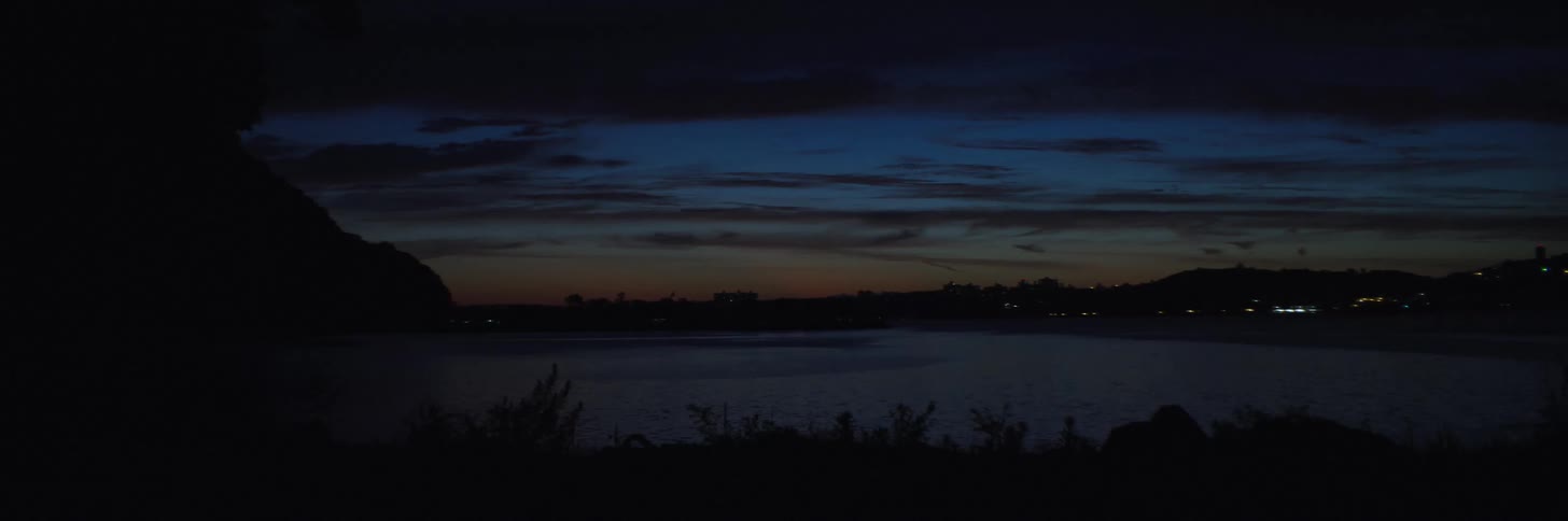 Camera tilts down to a landscape view of the coast with a skyline