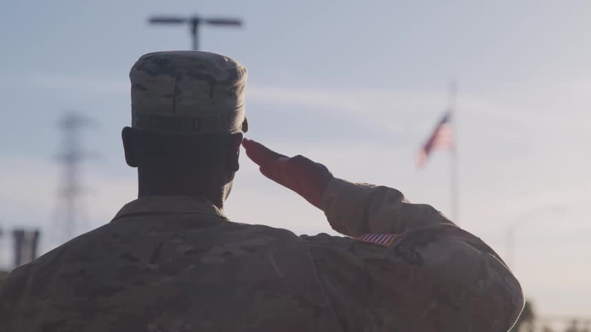 A soldier salutes the american flag