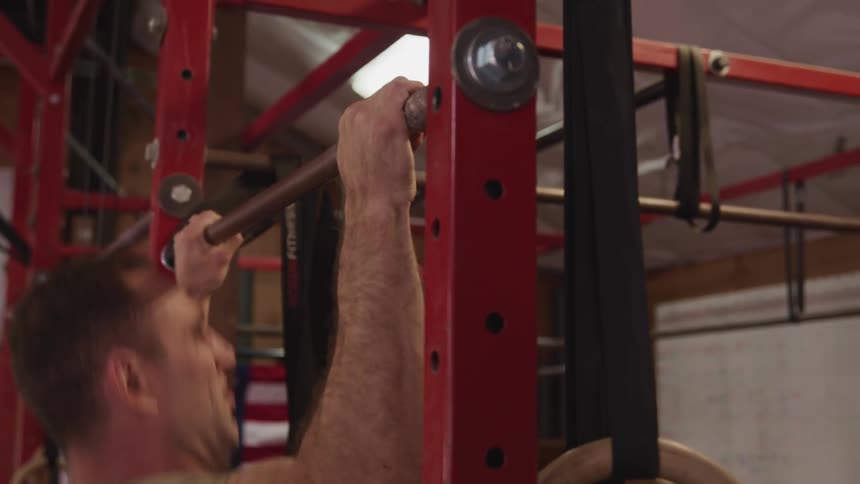 A man does pulls ups as he exercises