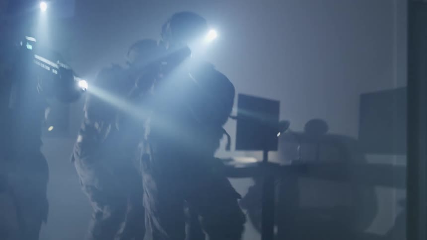 Papers are discarded on the floor of a building as soldiers storm in with flashlights and weapon drawn