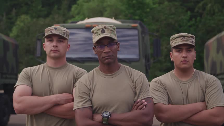 Three military men are standing outdoors in spring