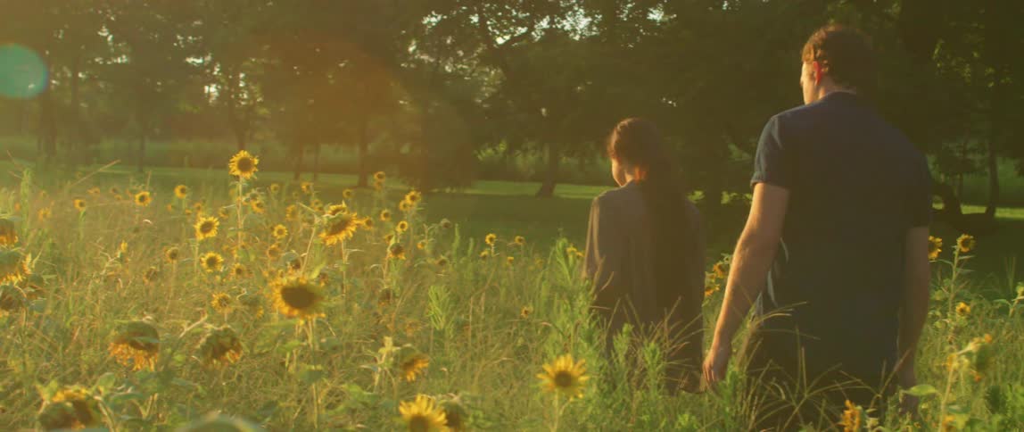 A man and woman walk through the flowers together