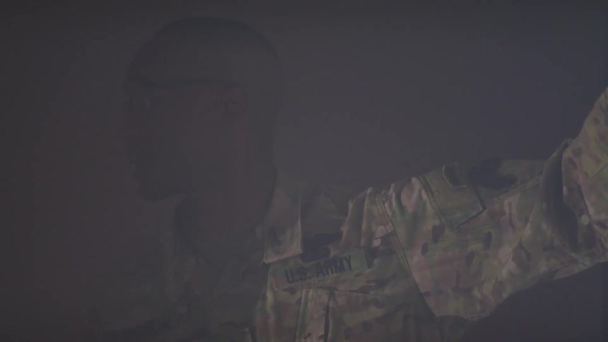 A soldier is pointing at a display on the wall