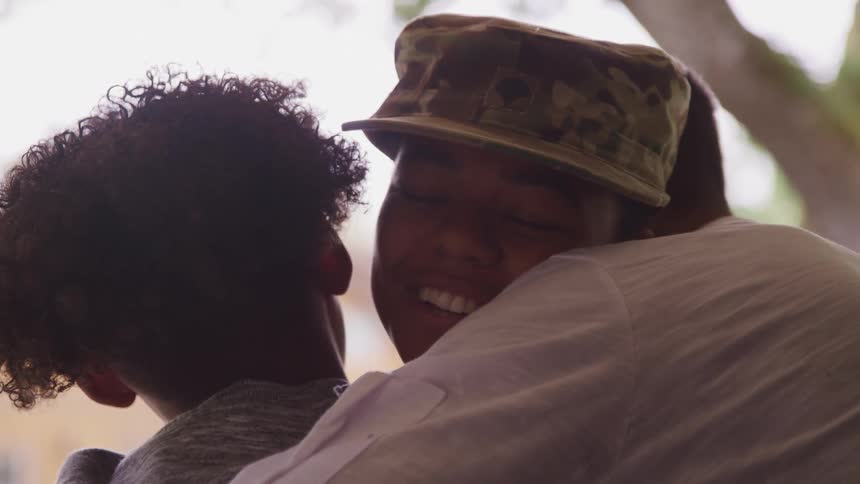Family welcoming with hughs a female american soldier home