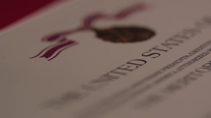 A formal document lays on the table and the camera changes focus a bit
