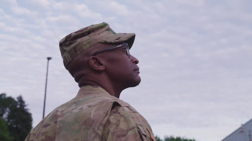 African american soldier looking up standing outdoors