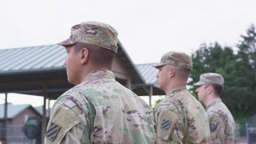 Three men in military uniform turn in unison