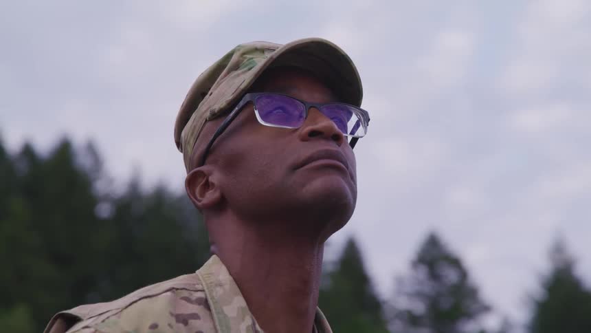 Military man wearing an army uniform looking up at the sky