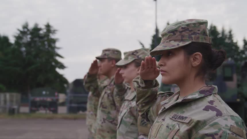 Troop of american soldiers saluting while standing in line in the yard