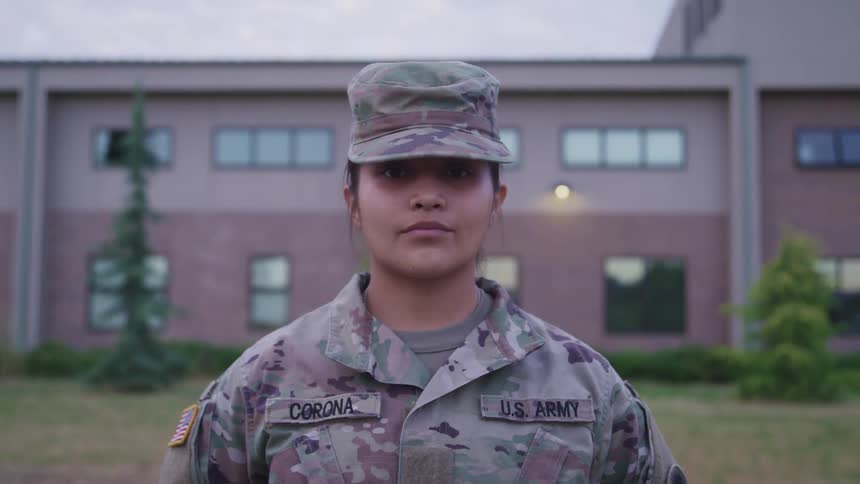 A soldier stands at ease in front of a building