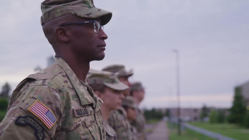 Men and women in military uniform stand in formation
