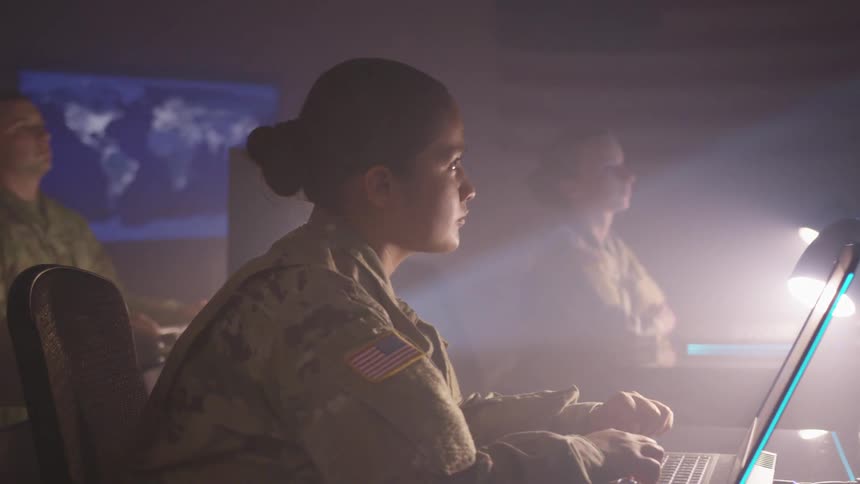 Us army troops sitting in a room in front of laptop computers