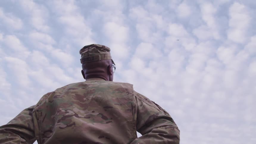 A soldier staring at the sky and clouds