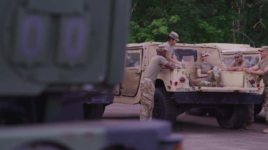 A group of soldiers sitting around on cars