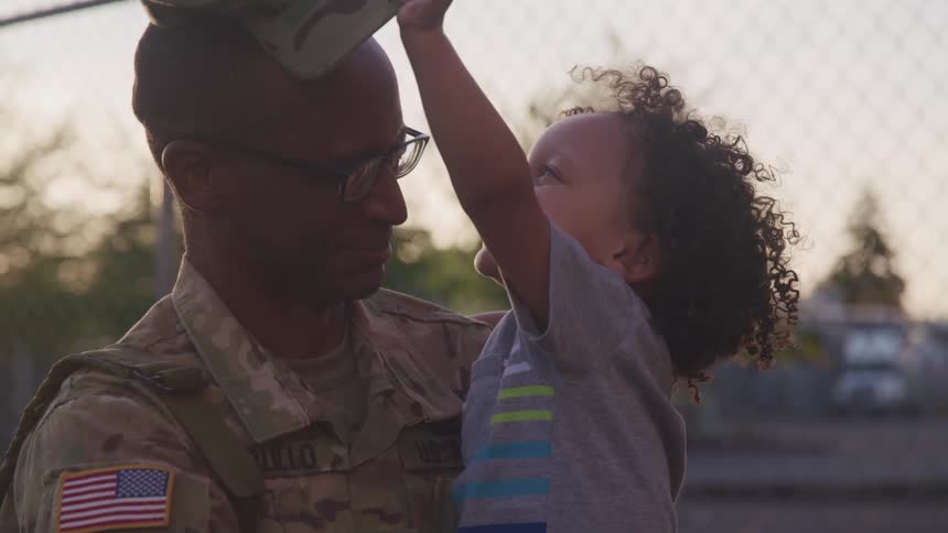 A son putting a hat on his fathers head