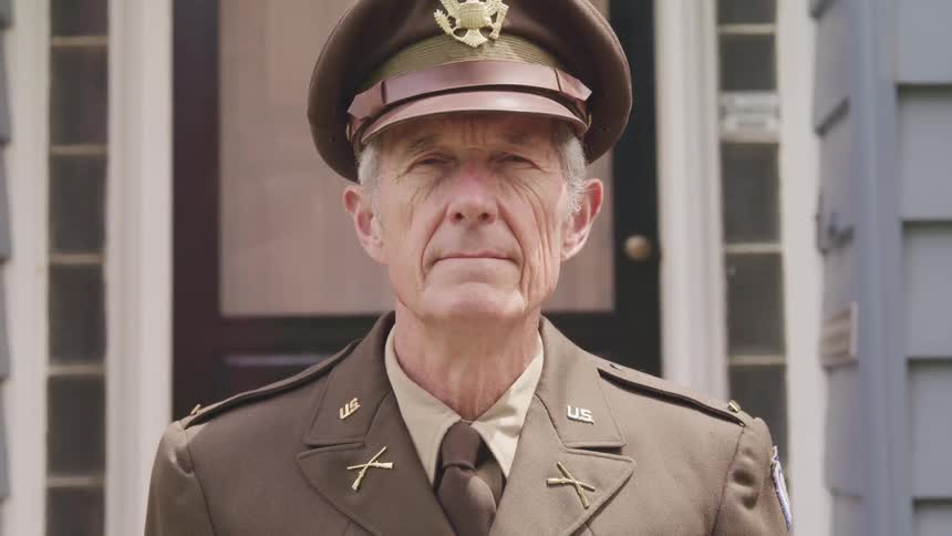 A man that is in a military suit and starting at the camera