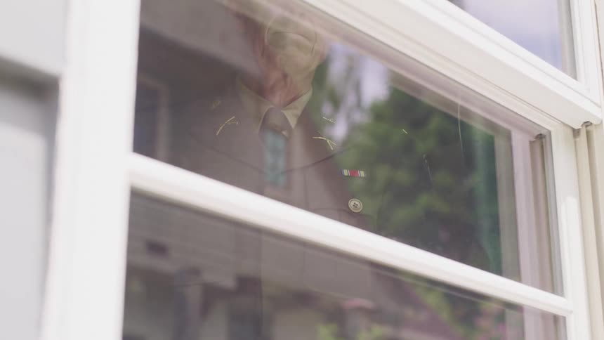 A man in a suit staring out of a window