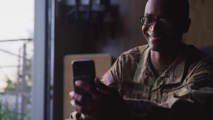 Man wearing fatigue sits video calling via mobile phone