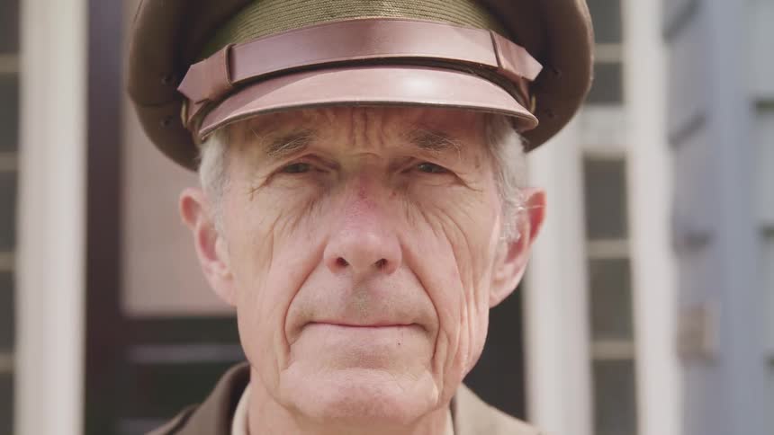 A military veteran in uniform raises his head and looks straight ahead