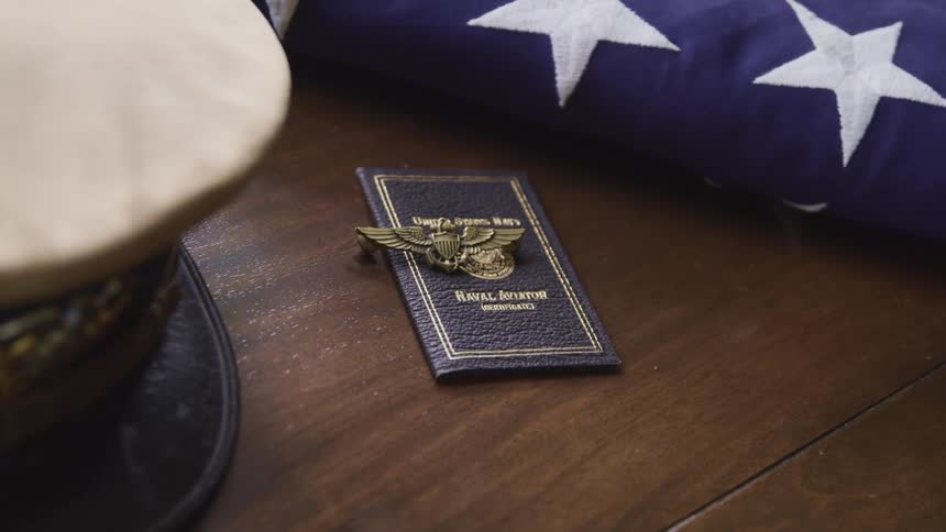 A table with a hat a military emblem and an american flag