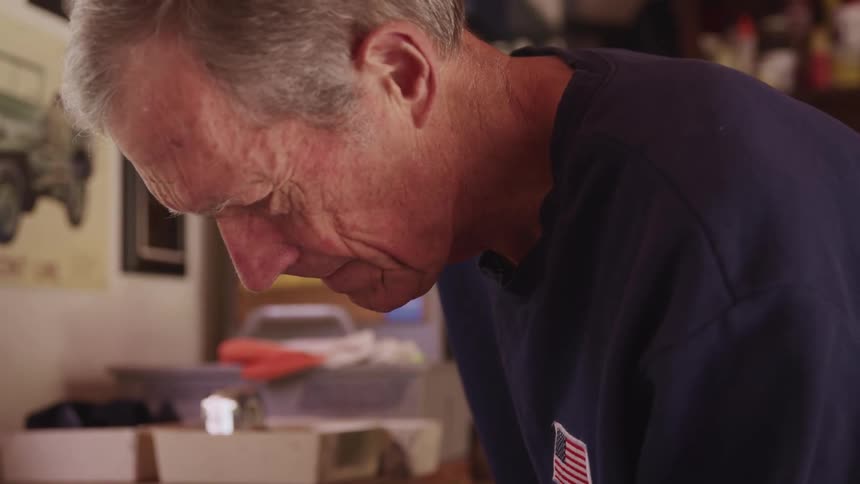 Elderly man working on a workbench in a workshop