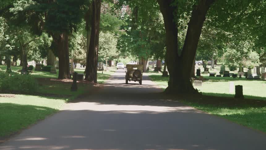 A vehicle drives past a cemetery