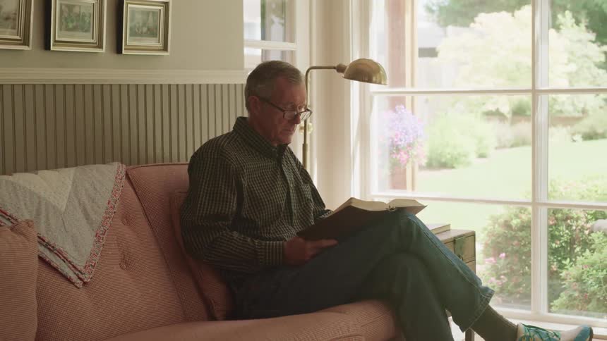 A man sitting around on a couch reading books