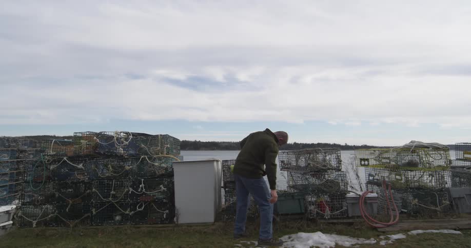 A man is checking on items by a wall