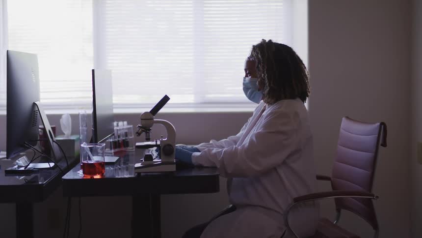 A doctor sitting at a desk typing on a computer