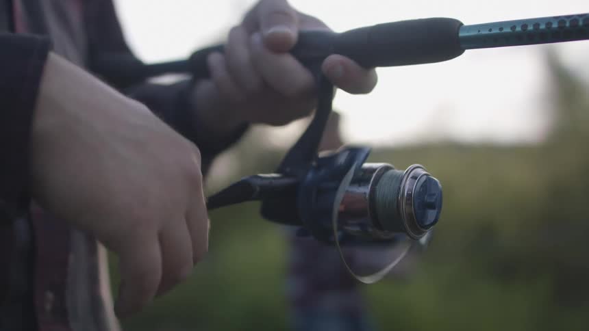 A person is fishing and reeling in his line