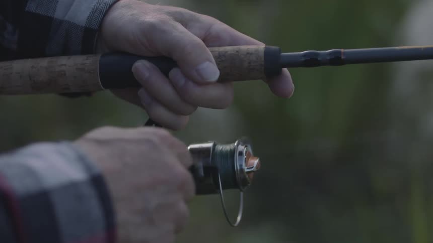 A man reeling in his fishing line