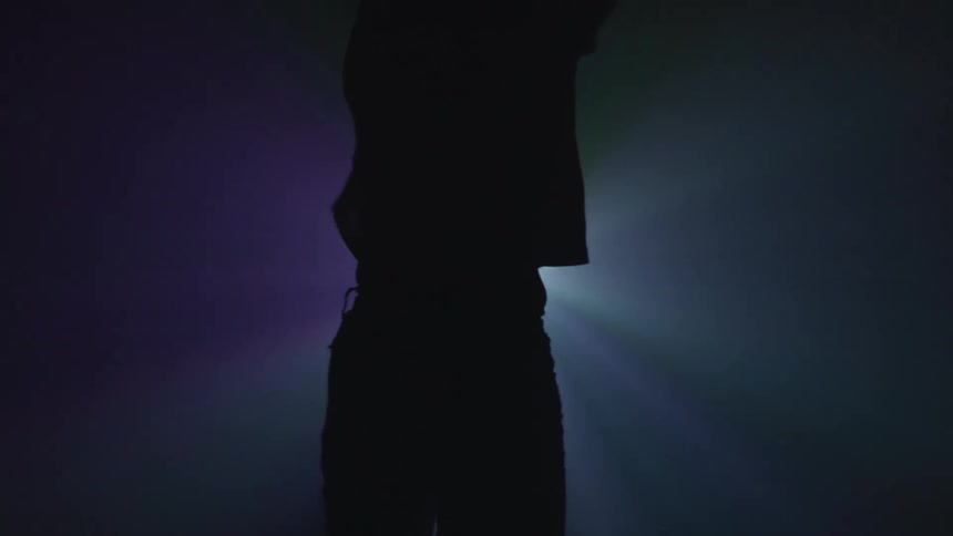 A woman is dancing next to flashing lights
