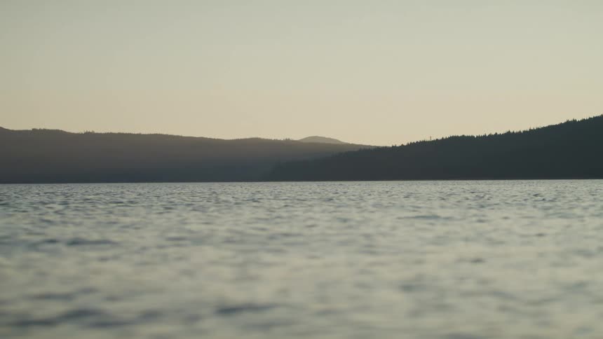 Water moving and rippling with mountains in the distance