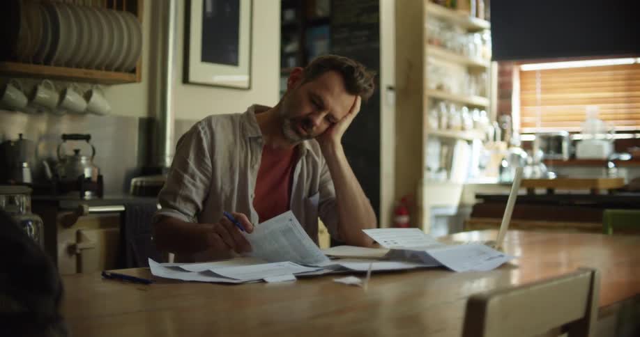 A man checking papers and doing calculations