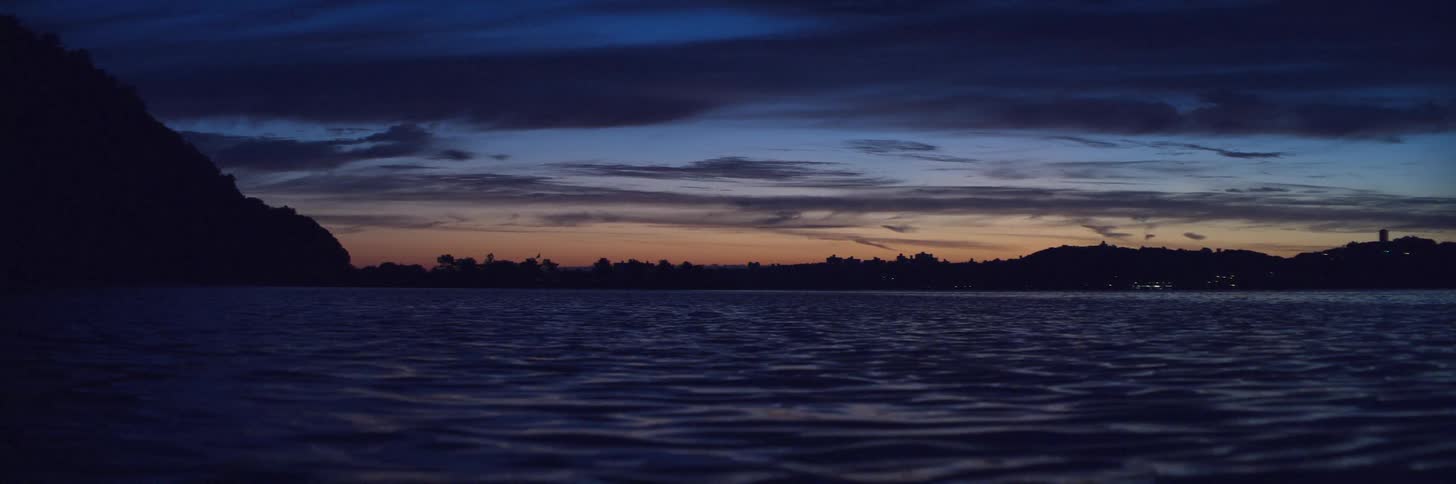 Calm waters of a lake near a small town in the mountains at sunset