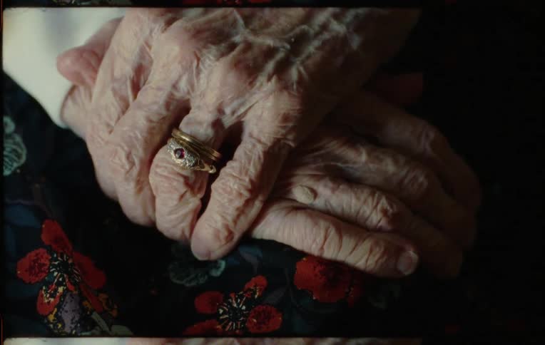 A person wearing a ring holds their hands together