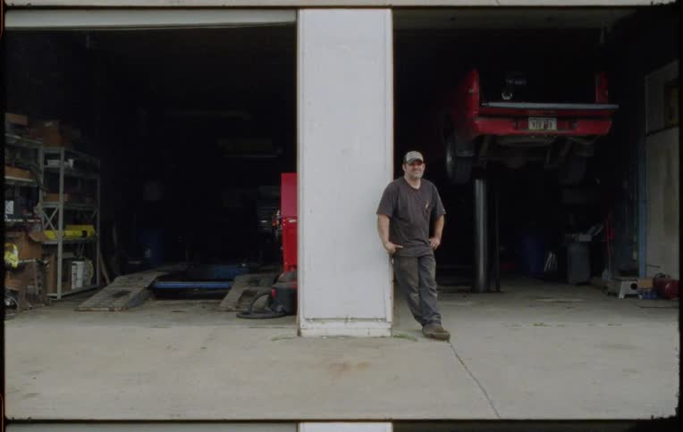 A mechanic standing outside of a shop