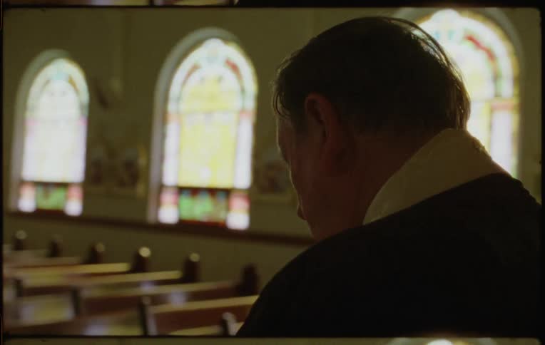 A priest setting a bible down on a lectern