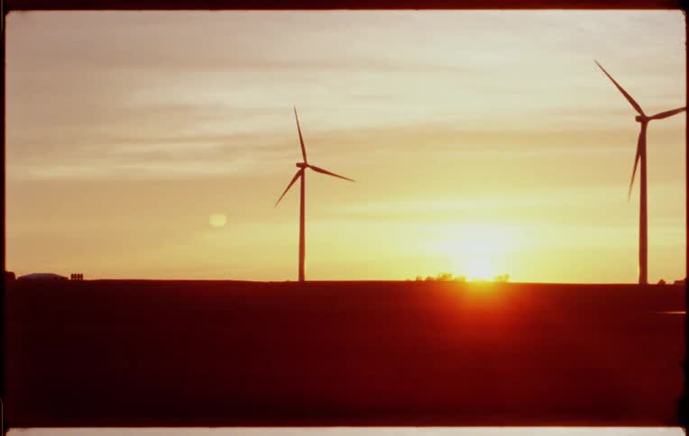 Windmills line the field at sunrise