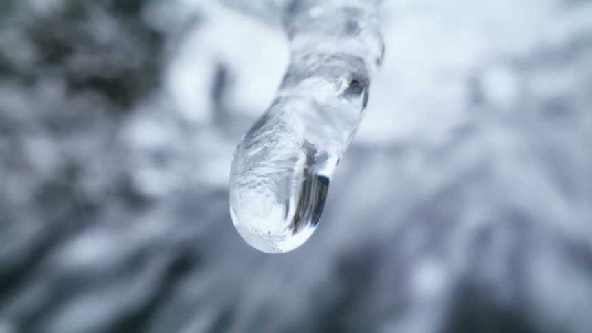 Water flowing behind a melting icicle
