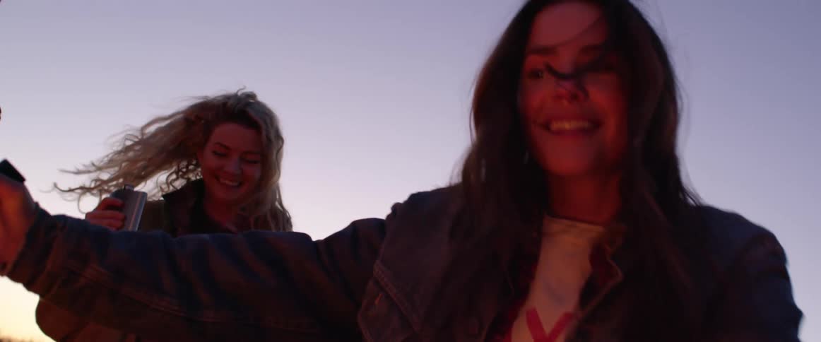 Two women dancing around outside