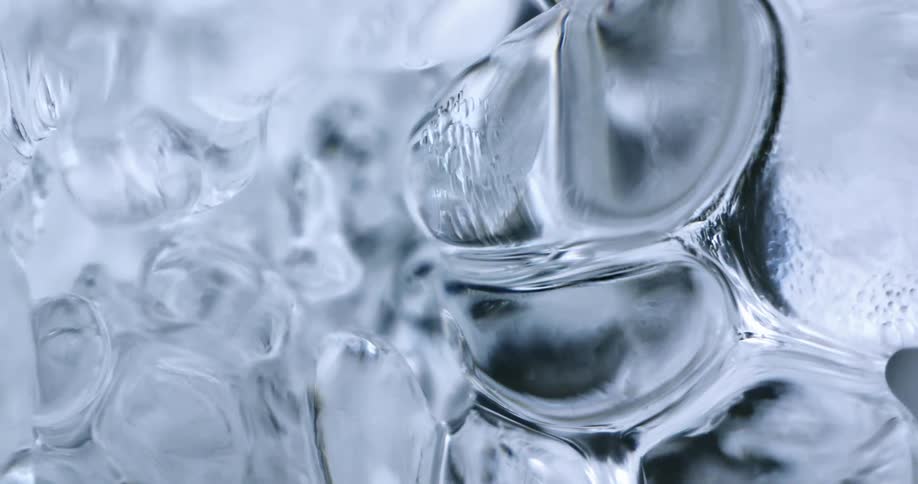 Water drop dripping from an sheet of ice hanging near a waterfall at winter