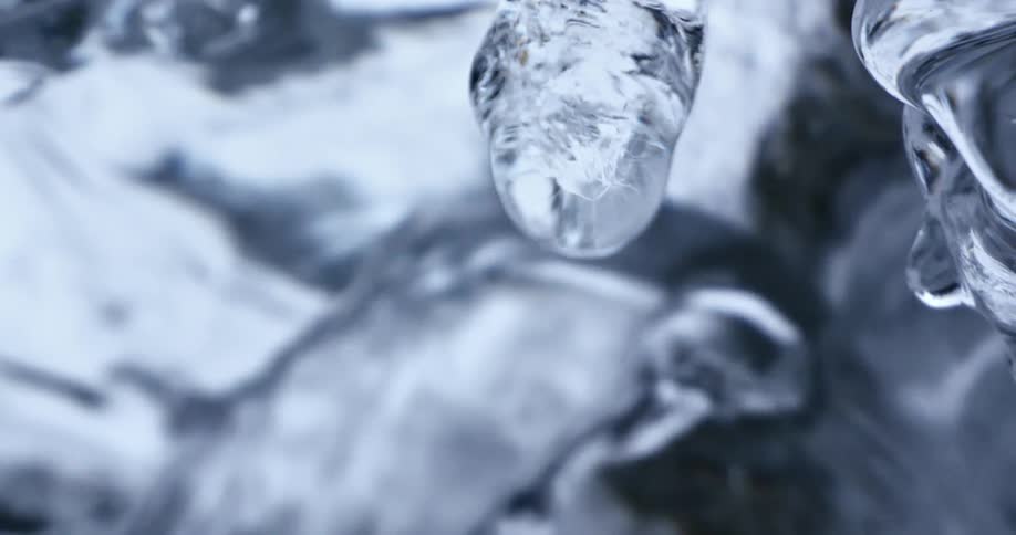 Water drips from ice onto flowing water