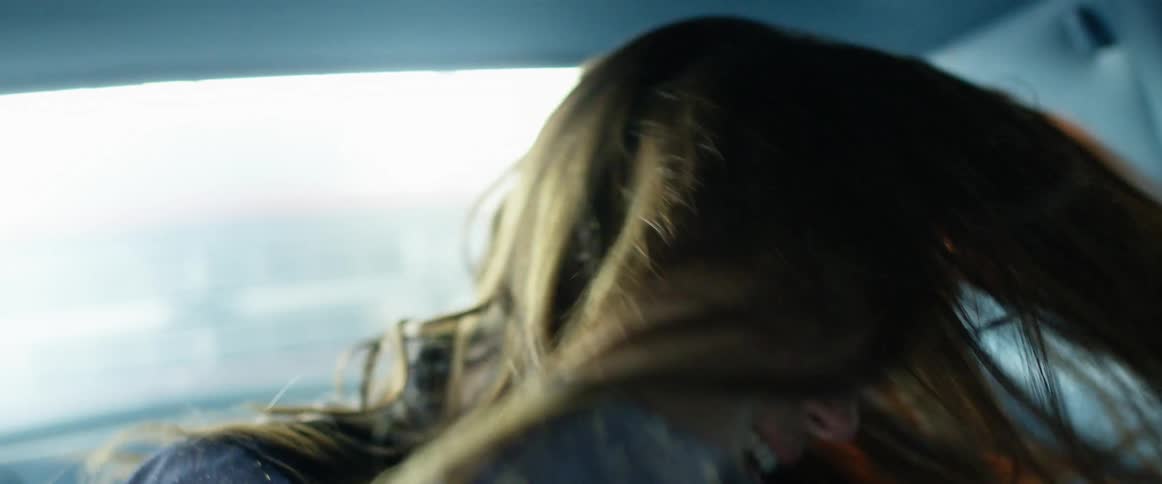 A woman in the back of a vehicle dancing to music