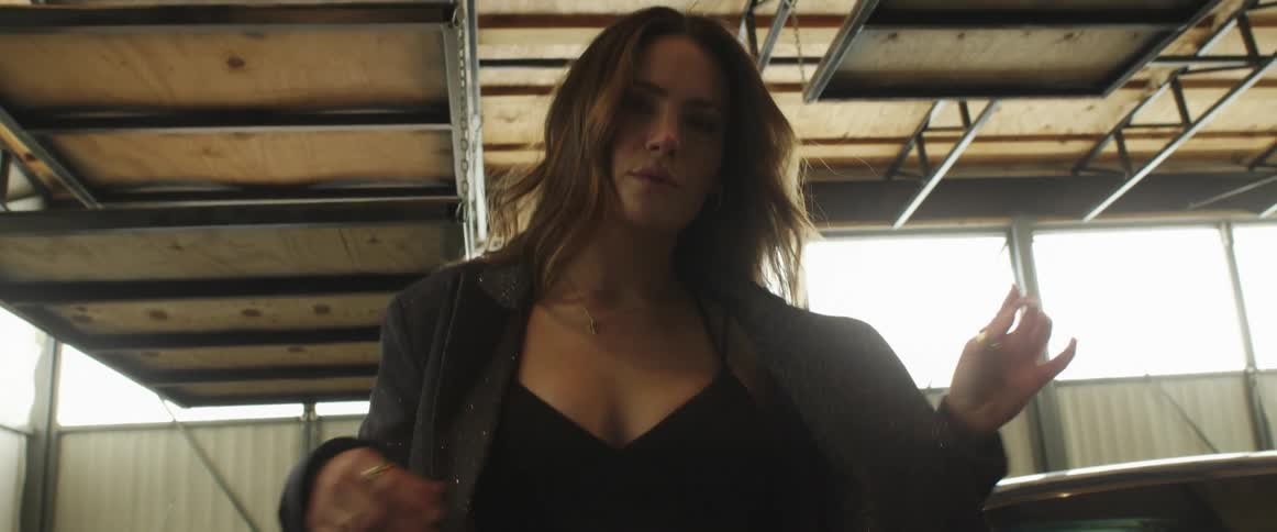 A woman dancing in a garage with cars
