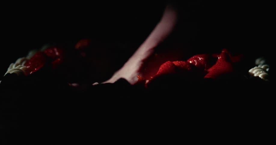 A person in a room putting their foot in a cake